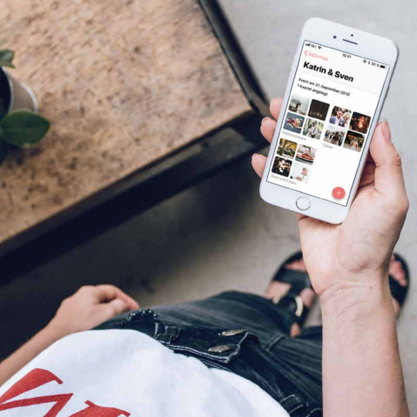 Person, die ein Smartphone mit Fotos in der Hand hält