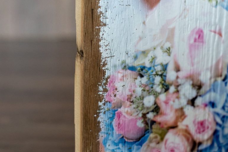 Detailaufnahme Druck mit Blumen auf Holz