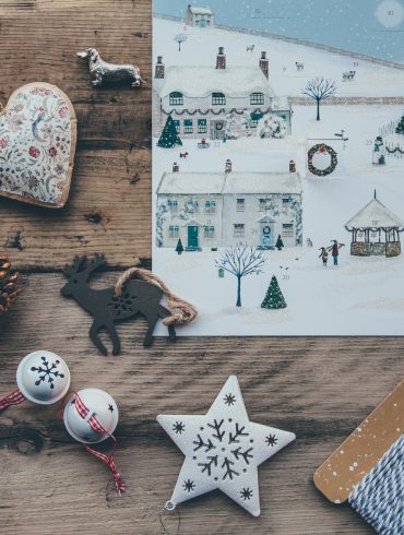 Adventskalender und Adventsdekoration auf Holztisch