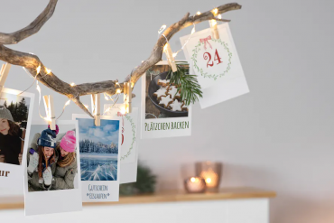 dekorierter Ast mit Adventskalender-Postkarten