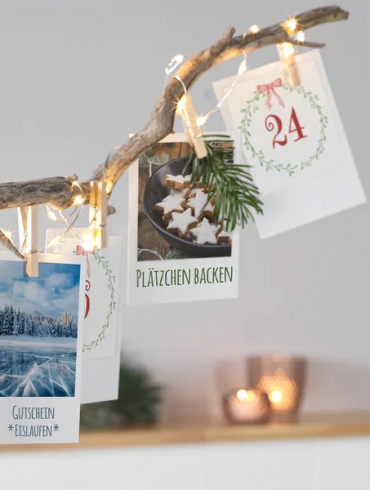 dekorierter Ast mit Adventskalender-Postkarten