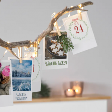 dekorierter Ast mit Adventskalender-Postkarten